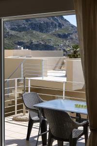 a patio with a table and chairs on a balcony at Plakias Panorama Homes in Plakias