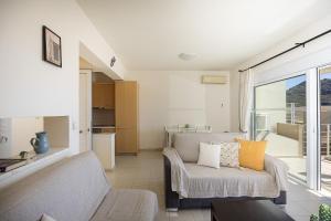 a living room with a couch and a kitchen at Plakias Panorama Homes in Plakias