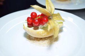 ein Dessert auf einem weißen Teller mit Obst darauf in der Unterkunft Hotel Rodewisch in Rodewisch