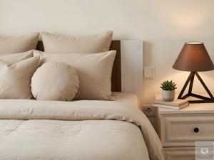 a bed with white pillows and a lamp on a night stand at RentHouse Apartments Cozy Stay in Chişinău
