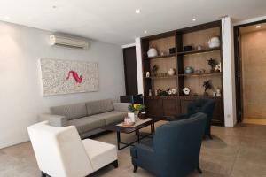 a living room with a couch and a table and chairs at Nivasa Hotel in Nusa Dua