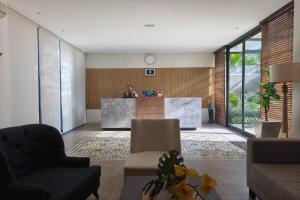 a man standing at a reception desk in a lobby at Nivasa Hotel in Nusa Dua