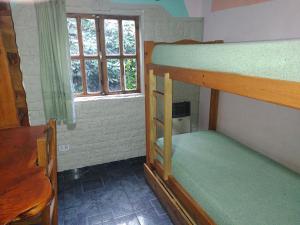 a room with two bunk beds and a window at departamentos privados de 2 a 8 pax equipados in El Hoyo