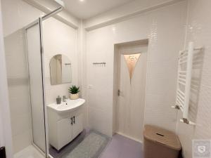 a white bathroom with a sink and a mirror at RentHouse Apartments Cozy Stay in Chişinău +17 photos