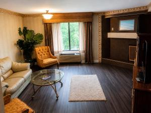 a living room with a couch and a glass table at Chateau Royale Inn in Lake Geneva