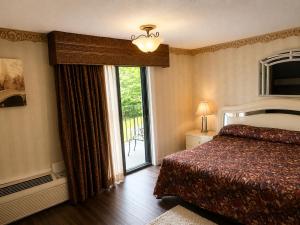 a bedroom with a bed and a sliding glass door at Chateau Royale Inn in Lake Geneva