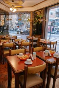 a restaurant with wooden tables and chairs and a street at Eleven Palace Hotel in Buenos Aires