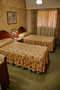 a hotel room with two beds and a window at Eleven Palace Hotel in Buenos Aires