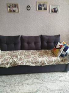 a long couch with a blanket on it in a room at Beka guest house in Karakol