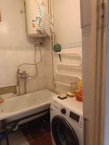 a laundry room with a washing machine and a sink at Beka guest house in Karakol