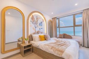 a bedroom with a bed and a large mirror at The Song Apartment Vung Tau - Căn Hộ Du Lịch 5 Sao Cạnh Biển Vũng Tàu in Vung Tau