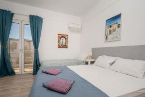a bedroom with two beds and a window at Karavaki apartments in Keri