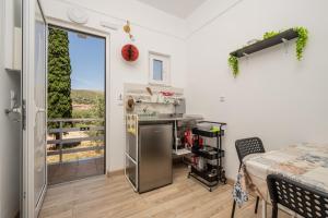 a kitchen with a counter and a table and a window at Karavaki apartments in Keri