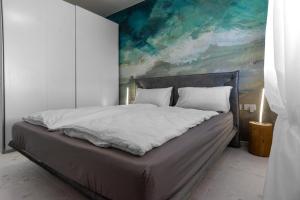 a bed in a bedroom with a painting on the wall at Garda Dolce Vita in Torri del Benaco