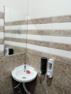 a bathroom with a sink and a mirror at Elegant Inn Hotel in Surat