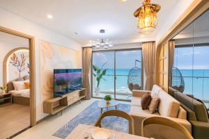 a living room with a couch and a tv at The Song Apartment Vung Tau - Căn Hộ Du Lịch 5 Sao Cạnh Biển Vũng Tàu in Vung Tau