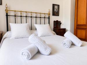 two white towels are on a white bed at Airtegal Casa da Praia Cedeira in Cedeira