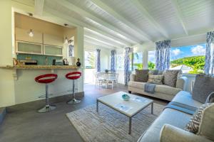 a living room with a couch and a table at Antigua Village Beach Resort in Saint Johnʼs