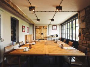 a large conference room with a large wooden table at Auberge de Temple in Johannesberg