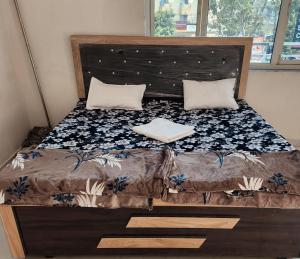 a bed with a wooden headboard and pillows on it at Shri om paradise inn in Mathura