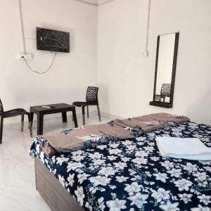 a bedroom with a bed and a table and chairs at Shri om paradise inn in Mathura