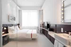 ein Hotelzimmer mit Bett und Waschbecken in der Unterkunft Ruby Leni Hotel Dusseldorf by IHG in Düsseldorf