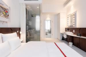 ein Schlafzimmer mit einem weißen Bett und ein Badezimmer in der Unterkunft Ruby Leni Hotel Dusseldorf by IHG in Düsseldorf + 76 Fotos