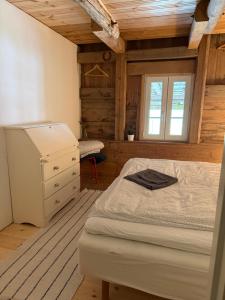 a bedroom with a bed and a dresser and a window at Isomegård Väte Gotland in Klintehamn