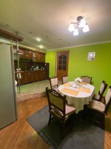 a dining room with a table and a green wall at Літо in Bushtyno