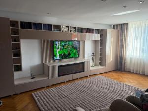 a living room with a tv and a fish aquarium at Cu Tâmpa la fereastră - Spacious Apartment with Mountain View & 2 Free Parking Spaces in Braşov