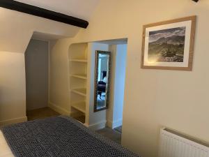 a bedroom with a bed and a mirror on the wall at Tafarn Penllan White Horse in Llanrwst