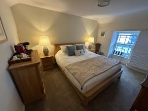 a bedroom with a large bed and a window at Tafarn Penllan White Horse in Llanrwst