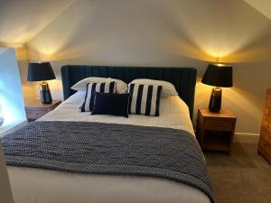 a bedroom with a bed with pillows and two lamps at Tafarn Penllan White Horse in Llanrwst
