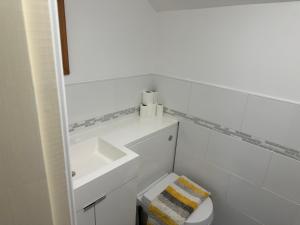 a white bathroom with a sink and a toilet at Tafarn Penllan White Horse in Llanrwst