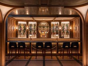 a bar with a bunch of chairs in a room at Mondrian Hong Kong in Hong Kong