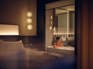 a woman in a bath tub in a hotel room at Pullman Auckland Airport in Auckland