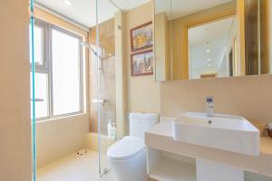 a bathroom with a sink and a toilet and a mirror at The Song Apartment Vung Tau - Căn Hộ Du Lịch 5 Sao Cạnh Biển Vũng Tàu in Vung Tau +91 photos