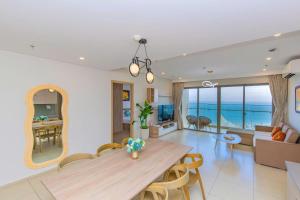 a dining room and living room with a table and chairs at The Song Apartment Vung Tau - Căn Hộ Du Lịch 5 Sao Cạnh Biển Vũng Tàu in Vung Tau