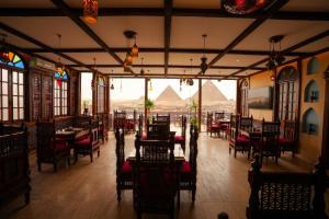 an empty restaurant with a view of the pyramids at Pyramids Hostel in Cairo