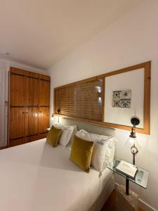 a bedroom with a large white bed and a table at Otília Apartamentos in Lisbon