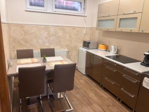 a small kitchen with a table and chairs in it at Origo Vendégház in Sárospatak