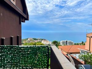 a building with a green hedge on a balcony at Infinity Blue in Cefalù +17 photos