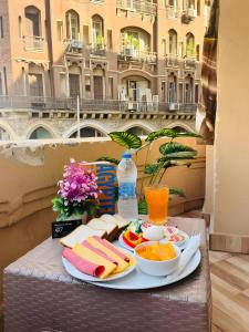 a tray of food on a table with a view of a building at The Rivénto Boutique with Breakfast - Downtown,Cairo in Cairo