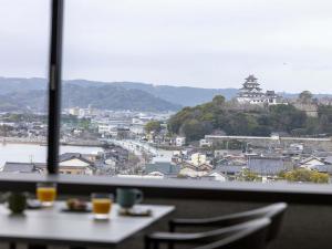 a table with a view of a city from a window at Mercure Saga Karatsu Resort in Karatsu