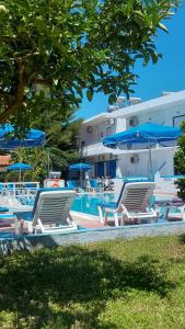 a group of chairs and umbrellas next to a pool at Kosinmyheart Apartment 11 & Studio10 in Kos