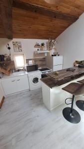 a kitchen with white cabinets and a stove top oven at La tête dans les étoiles - Appartement climatisé - 2 Chambres in Ruffec