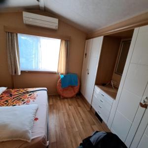 a small bedroom with a bed and a window at Camping les cigales 5 étoiles in Le Muy