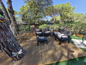 a patio with chairs and a table and a tree at Camping les cigales 5 étoiles in Le Muy +5 photos