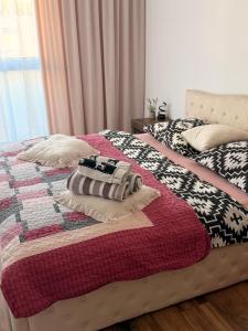 a bed with a quilt and pillows on it at Apartament Lniany in Leszno