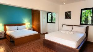 a bedroom with two beds and two windows at Tropical Casa Laguna in Cabarete +139 photos
